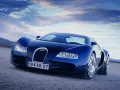 Niebieski Bugatti Veyron na pustynnym tle pod błękitnym niebem.