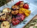 Gegrilltes Gemüse wie Zucchini, Paprika und Tomaten, garniert mit Rosmarin. Perfekt für Ihre nächsten BBQ Rezepte!