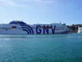 Ogromny prom GNV Orion czeka na pasażerów, by zabrać ich w podróż na Sycylię. W tle widać port i wzgórza.
