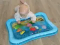 Niemowlę bawi się na macie wodnej dla niemowląt z morskimi stworzeniami.