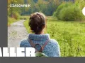 Osoby po francusku, spacerujące jesienną alejką wśród kolorowych drzew.
