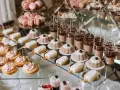 Słodki stół jak zrobić samemu: różowe makaroniki, kremowe babeczki, czekoladowe deserki w pucharkach i lodowe lizaki.