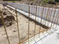 Budowa fundamentów: pionowe i poziome zbrojenie czeka na beton.