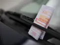 Ein Strafzettel unter dem Scheibenwischer. Parken ohne Parkschein kostet Geld und Ärger.