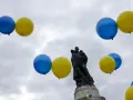 Niebiesko-żółte balony unoszą się nad pomnikiem, symbolizując ukraińską kulturę i tradycje.
