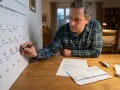 Mann markiert Fristen im Kalender. Was tun, wenn die Versicherung nicht zahlt? Er prüft Dokumente und Belege.