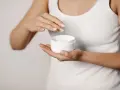 Manos aplicando crema para suavizar la piel y tratar la queratosis pilaris.