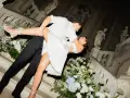 Un couple s'embrasse passionnément sur un escalier orné de fleurs, un moment clé pour réussir son mariage.