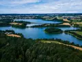 Malownicze jeziora i lasy tworzą tajemnicze miejsca na Kaszubach. Widok z lotu ptaka ukazuje spokojne wody, zielone wyspy i pola uprawne.