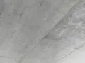 Surowy, betonowy sufit z widocznymi liniami szalunku. Betonowy sufit inspiracje dla minimalistycznych wnętrz.