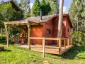 Il progetto di una piccola casa di campagna, con tetto spiovente, camino e un albero che attraversa la struttura.