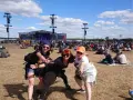 Trzy kobiety bawią się na festiwalu czaplinek pol and rock. W tle scena i tłum ludzi.