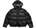 Piumino nero Stussy con cappuccio e logo bianco sul petto. Perfetto per affrontare il freddo con stile.