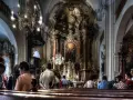 Wnętrze kościoła z bogato zdobionym ołtarzem. Ludzie siedzą w ławkach, słuchając kazania. Czy to czas na gorzkie żale?