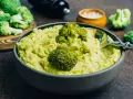 Un bol de purée de brocolis onctueuse, garni de fleurettes de brocolis et d'épices rouges. Un délice vert et sain.