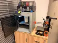 Test drukarki 3D Bambu Lab X1-Carbon z AMS i małą drukarką Prusa Mini obok.