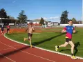 Coureurs sur piste, s'entraînant pour savoir combien de jours de repos avant une compétition. Le soleil brille sur la piste d'athlétisme.