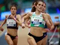 Corredoras en competición de atletismo femenino España. La atleta con el dorsal 412 lidera la carrera, mostrando su determinación.