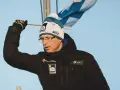 Igor Medved w czapce z pomponem i flagą Finlandii, w czarnej kurtce z logo.