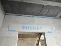 Dylatacja co to? Widoczna szczelina wypełniona pianką między betonem a bloczkami z napisem SOLBET.