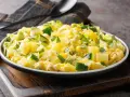 Zarangollo murciano, un plato casero con patatas, calabacín y huevo, adornado con perejil fresco.