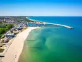 Słoneczna plaża Władysławowo z portem i turkusową wodą Bałtyku.