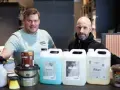 Två män presenterar produkter för att lasera altan. En burk med träolja och flera flaskor med rengöring och skydd.