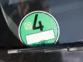 Grüne Umweltplakette mit der Nummer 4. Diese zeigt, welche Schadstoffklasse ist gut für die Umweltzone.