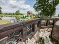 Para rowerzystów odpoczywa przy śluzie, podziwiając malownicze **trasy rowerowe Augustów**.
