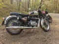 Royal Enfield Classic 350 dane techniczne: brązowy motocykl w lesie, obok czerwony. Klasyka i moc.