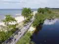 Rowerzyści przemierzają malowniczą trasę EuroVelo 10 wzdłuż plaży i spokojnej wody.