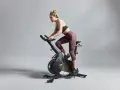 Kvinna cyklar intensivt, redo för tuffa tabata intervaller.