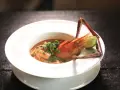 Sopa de marisco con gamba, lima y chile en plato blanco.