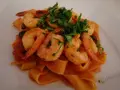 Pappardelle z krewetkami i pomidorkami, posypane świeżą natką pietruszki. Pyszne danie, które zachwyci każdego smakosza.
