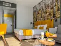 Pokój hotelowy z motywem lasu, żółtym akcentem i napojami. Idealne miejsce na relaks, jak sugerują notera hotel spa opinie.