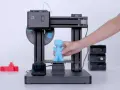 Drukarka 3D MOOZ tworzy niebieską figurkę. Zastanawiasz się, ile prądu zużywa drukarka 3D?