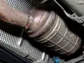 Rdza na katalizatorze Renault, możliwy błąd DTC P0420. Widoczny fragment układu wydechowego.