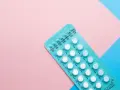 Opakowanie tabletek antykoncepcyjnych na różowym i niebieskim tle. Szukasz co zamiast tabletek antykoncepcyjnych?