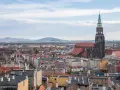 Widok na Świdnicę z górującą nad miastem wieżą katedry. W oddali widać góry. To jedne z głównych świdnica atrakcje.