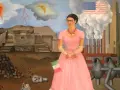 Frida Kahlo w różowej sukni, z flagą Włoch, na tle fabryki Forda i piramidy. Jej niepełnosprawność jest widoczna w jej postawie.
