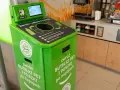Zielony automat do zwrotu butelek PET i puszek. Skanuj kod, wrzuć opakowanie, by zdjąć zabezpieczenie sklepowe z butelki i otrzymać kaucy.