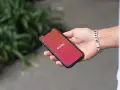 Dłoń trzyma smartfon z logo Tinder. Zastanawiasz się, czy Tinder jest płatny? Aplikacja oferuje darmowe funkcje, ale płatne subskrypcje dają więcej możliwości.