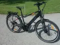 Svart elcykel, modell MOMAS JASON URBAN, redo för ett momas elcykel test. Ställning bak, skärmar och reflexer syns tydligt.