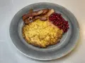 En tallrik med raggmunk, stekt fläsk och lingon. Ett klassiskt svenskt raggmunk recept som är perfekt för en mysig middag.
