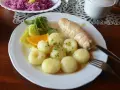Pyszne kluski śląskie z roladą mięsną, surówką z czerwonej kapusty i plasterkiem pomarańczy.