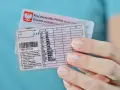 Polskie prawo jazdy z kategoriami, w tym kat. B, w dłoni. Dokumenty do prowadzenia pojazdów.