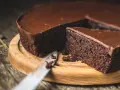 Wilgotne, najprostsze ciasto czekoladowe z błyszczącą polewą, pokrojone na kawałki, czeka na spróbowanie.