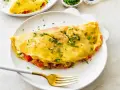 Złocisty omlet z białek, nadziany warzywami i serem, posypany szczypiorkiem. Idealny na lekki posiłek.