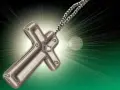 Metalowy krzyż na łańcuszku, symbol wiary i religii w Polsce, emanuje światłem.
