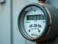 Cyfry z licznika gazu: 111 i 38.30 m³. Widoczny cyfrowy wyświetlacz z odczytem zużycia.